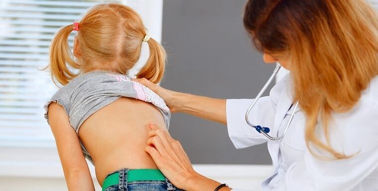 Doctor examinando la espalda de un niño para detectar dolor lumbar